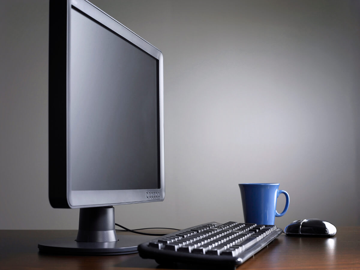 A monitor and keyboard on a tidy desk.